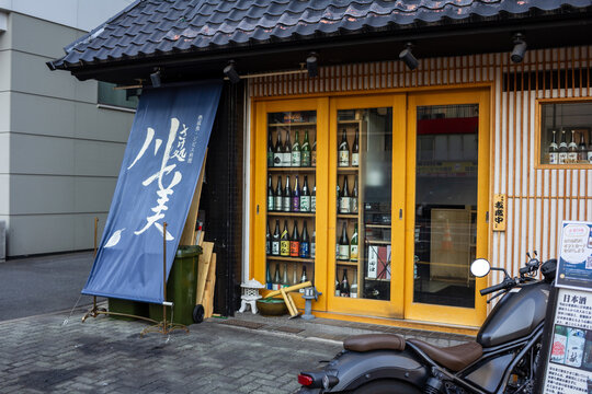 Tokyo, Japan, 2 November 2023: Traditional Japanese sake shop with blue noren curtain.