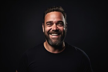 Portrait of a happy man with a beard on a dark background