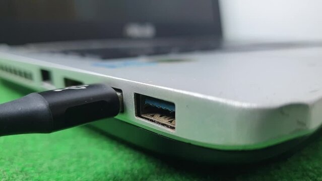 Black and white USB cable that is Plugged and unplugged from the USB port on a Laptop or Notebook