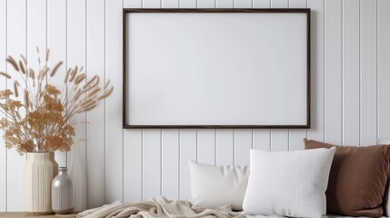 Hanging Empty black wooden frame on a white wood line wall texture with pillows, beige fabric, and a vase on a brown wooden table