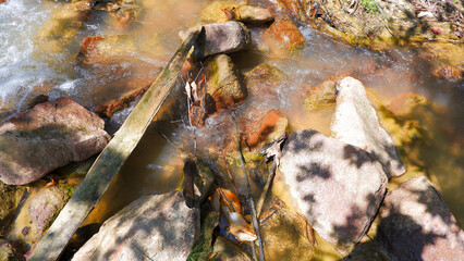 Fresh natural small river flowing from the mountains, with a stretch of rocks