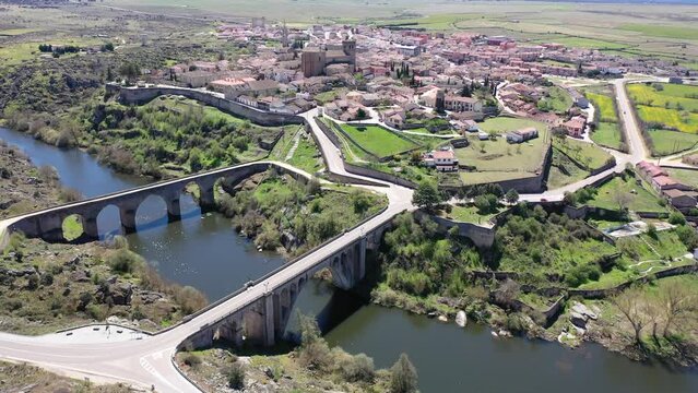 Picturesque aerial view of small old Spanish walled township of Ledesma with terracotta tiled roofs of residential houses 