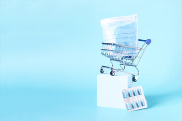 Pills and medical masks in a grocery basket on a light background are a place for text.