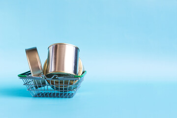 Canned food in a basket with various products in close-up on a colored background. Long-term storage products.