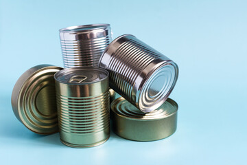 Tin cans with various products in close-up on a colored background. Long-term storage products.
