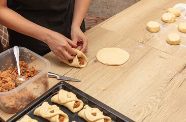Woman preparing buns with jam from doug