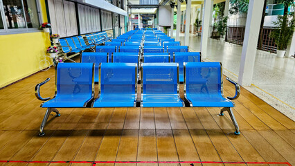 Blue chairs in a row. Empty blue seats in waiting room of a hospital. Row of blue chairs in the...