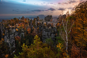 Saxon, Germany - The Bastei bridge with a sunny autumn sunrise with colorful foliage and sky. Bastei is famous for the beautiful rock formation in Saxon, Saxon Switzerland National Park