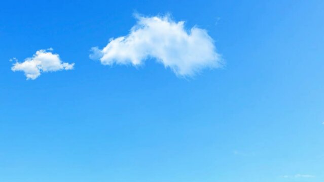 Beautiful white clouds approach the point of view backed by a vivid blue sky in this 20 second loop
