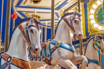 Old French carousel spins in a holiday park. Elephant horses on a traditional vintage fairground...