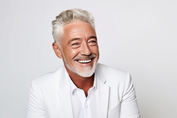 Handsome senior man with grey hair and beard smiling at camera