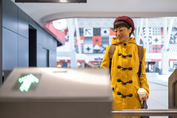 Woman passenger with backpack validating boarding pass ticket at the airport.