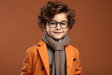 portrait of a cute little boy in an orange coat and glasses
