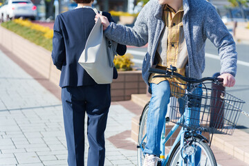 自転車に乗って鞄をひったくりする男性