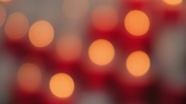 Blured A bunch of red and white candles are lit up in a row