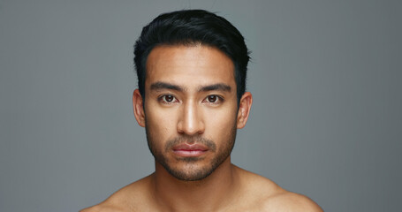 Face, cosmetics and Asian man with beauty, skincare and dermatology on a grey studio background....