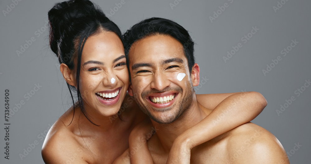 Sticker Couple, smile and love for skincare, care and portrait with moisturizer in studio by gray background. Happy people, dermatology and hug for cosmetics, hydration and creme or love for skin treatment