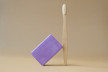 Bamboo toothbrush and Lavender soap on beige background with copy space for your text....