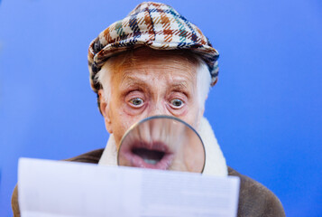Funny portraits with old grandmother. Senior woman acting as an investigator with the magnifying lense - 733637585