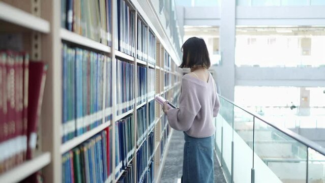 台湾台北市文山区の大学にある美しい図書館で過ごす20歳の台湾人女性の大学生のスローモーション映像 Slow-motion video of a 20-year-old Taiwanese female college student spending time in a beautiful library at a university in Wenshan District, Taipei 