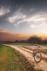 Naklejka premium A mountain bike stands in the middle of a dirt road in the mountains.