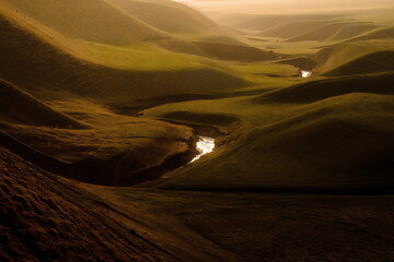 A fantastic landscape of a hilly valley with a river flowing through the middle. Kyrgyzstan
