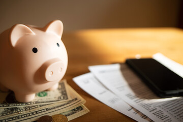 tax refund: piggy bank, money and Form 1040 on table.