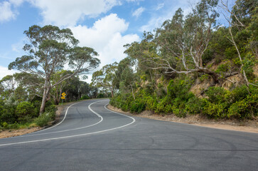 Background texture of a winding and curving scenic mountain highway. Australian country road lined...