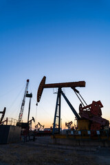 In the evening, oil pumps are running, Silhouette of beam pumping unit