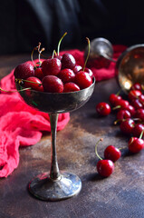 Ripe red cherries in an antique silver bowl