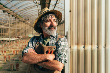 Farmer senior man working in his farm and greenhouse - 733664101