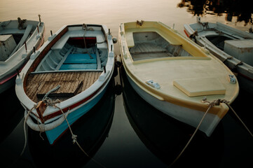 Fototapeta na wymiar Small boats on calm water, moored in the harbor during sunset.