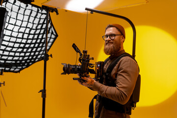 Professional videographer with camera equipment in studio.