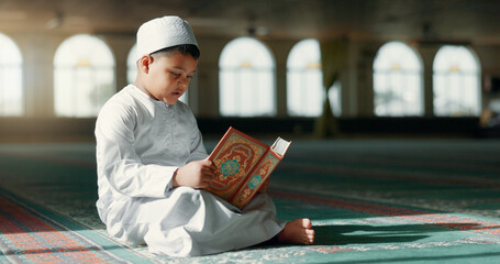 Islam, boy in mosque reading Quran for learning mindfulness and gratitude in faith with kids prayer. Worship, religion and Muslim student in holy temple praise with book, spiritual teaching and study