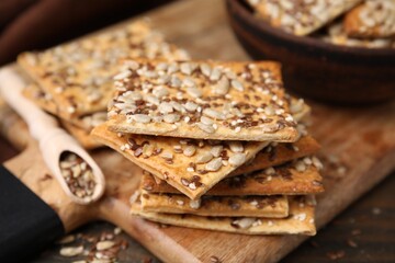 Cereal crackers with flax, sunflower and sesame seeds on table, closeup