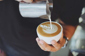 Person Serving Cup Coffee With Metal Jug