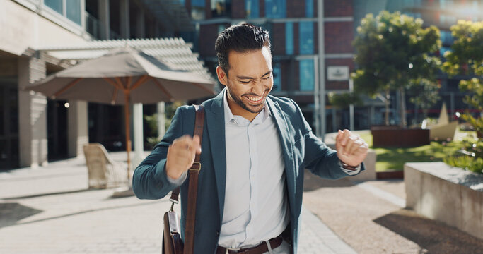 Happy, smile and businessman dancing in city for good news, achievement or celebration. Excited, success and professional young male person moving and singing with briefcase to music in urban town.