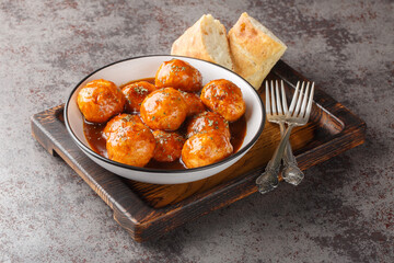 Spicy and sweet, chipotle honey glazed meatballs closeup on the bowl on the table. Horizontal