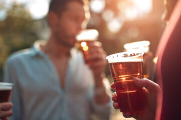Group of friends enjoying cold beer at a backyard party.