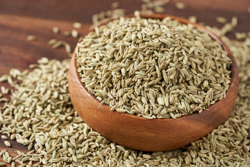 dry fennel seed sounf in wooden bowl on wood table food background closeup