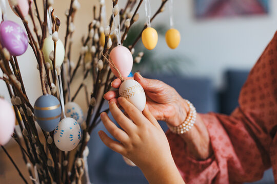 Close up of decorating pussy willows branches, putting easter eggs on them.