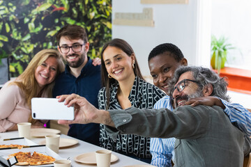 Selfie of a group of happy business people taking photo with a phone