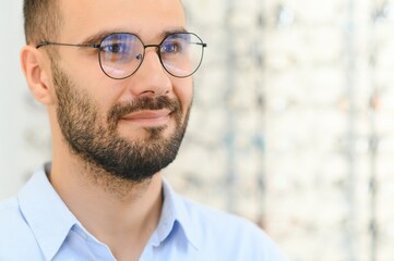 Obraz premium Glasses Shop. Man Trying On Eyeglasses In Optics Store