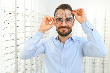 Glasses Shop. Man Trying On Eyeglasses In Optics Store