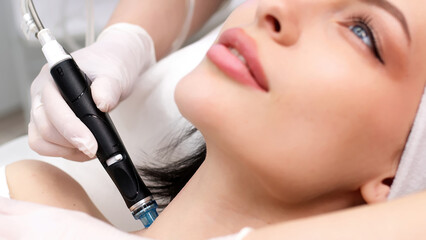 Close-up of a young woman receiving a facial peel. Woman in beauty spa.