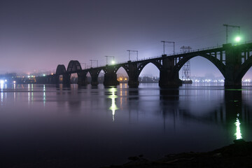 Fototapeta premium Scenic view of the city of Dnepr in the winter evening. Dnipro in the evening. Ukrainian city in winter at night. background image. Panoramic view. Long exposure photo of the Dnieper River at night.