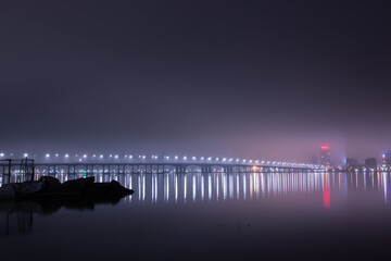 Fototapeta premium Scenic view of the city of Dnepr in the winter evening. Dnipro in the evening. Ukrainian city in winter at night. background image. Panoramic view. Long exposure photo of the Dnieper River at night.