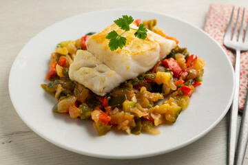 Cod tapa cooked with vegetables in samfaina. Traditional recipe of Spanish gastronomy.