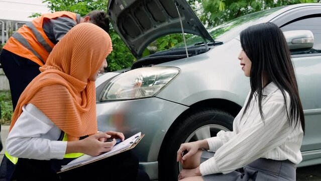 Muslim female car insurance agent, sit down talk with customer, look at condition car see what damage occurred where, in order proceed further, claim damages, woman sits talks calmly with officer.