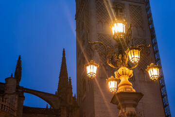 Fuente De La Farola Lamp Against Giralda Tower In Seville, Spain - 733716541